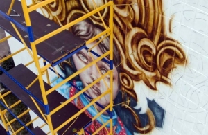 Дівчина з квіткою: у центрі Житомира відомий художник створює святковий мурал. ФОТО