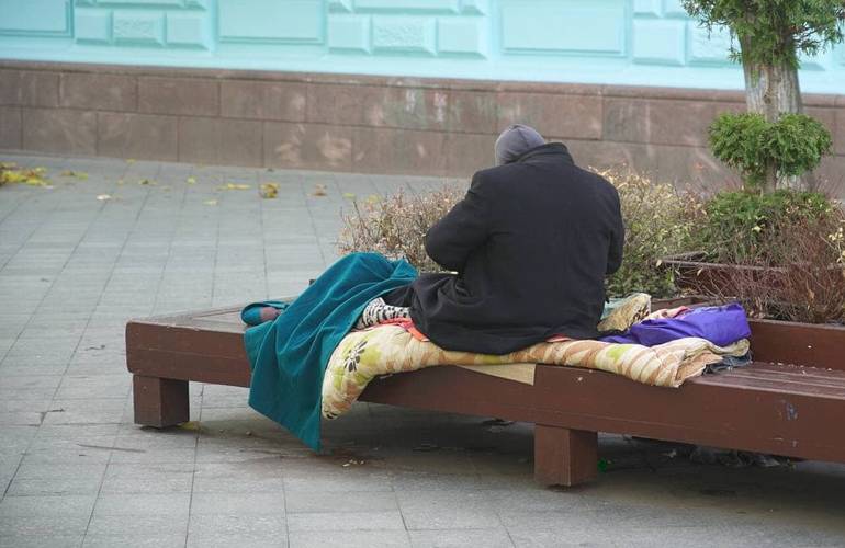 В Житомире бездомный поселился на лавке под мэрией. Горожане жалуются, а власть разводит руками