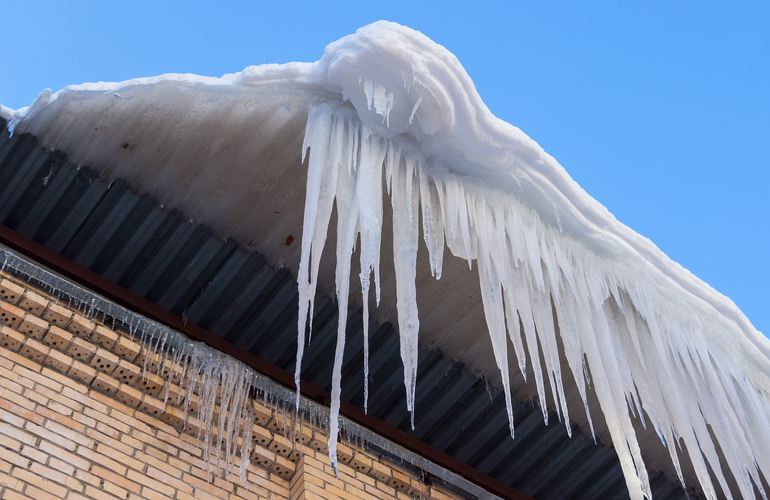 Житомирян предупреждают о риске схода с крыш домов снега и сосулек
